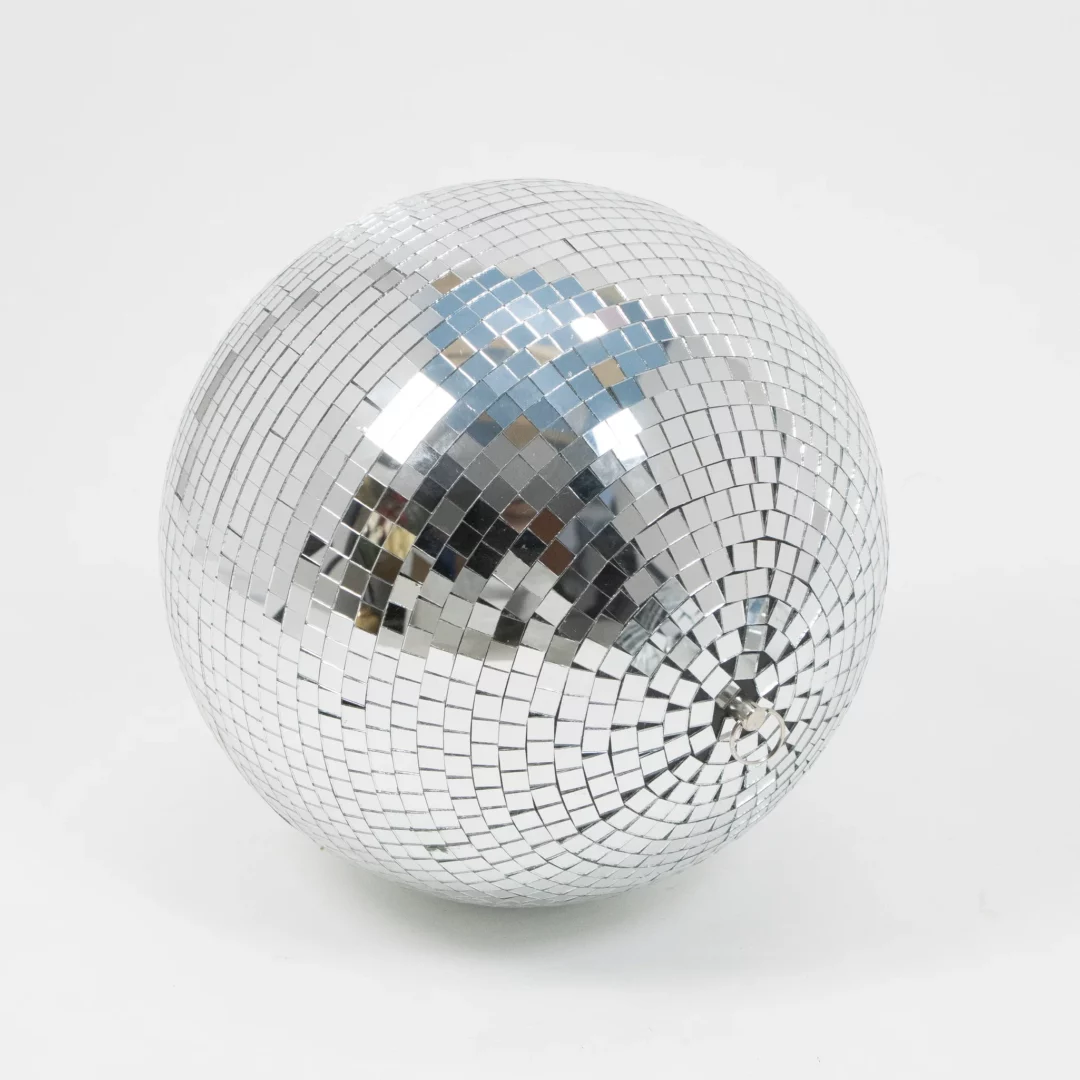 Kula Disco ⌀ 30 cm. Lustrzana kula dyskotekowa o średnicy 30 cm, pokryta kwadratowymi płytkami odbijającymi światło, idealna na wesele, dyskotekę czy inny event tematyczny, jak i do dekoracji scenograficznych. Dzięki efektownemu wyglądowi świetnie nadaje się do aranżacji parkietu tanecznego, podkreślając atmosferę imprezy. Kula wyposażona w metalowe oczko umożliwiające zawieszenie. Dostępna do wypożyczenia we Wrocławiu w ofercie Rent4Events.pl oraz Rent4Weddings.pl - rent4events.pl wypożycz wrażenia, rent4wedding.pl zachowaj wspomnienia.