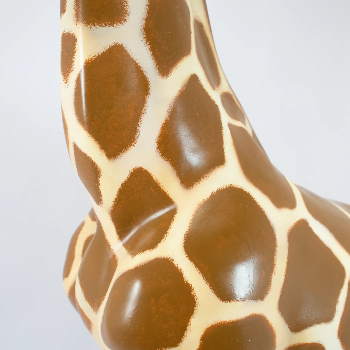Fragment figury żyrafy z realistycznym wzorem plam i gładką, połyskującą powierzchnią, ukazujący detale szyi i tułowia, idealny jako dekoracje na event tematyczny. Element scenografia dostępny w wypożyczalnia rent4events.pl i rent4weddings.pl z Wrocławia - rent4events.pl wypożycz wrażenia, rent4wedding.pl zachowaj wspomnienia.