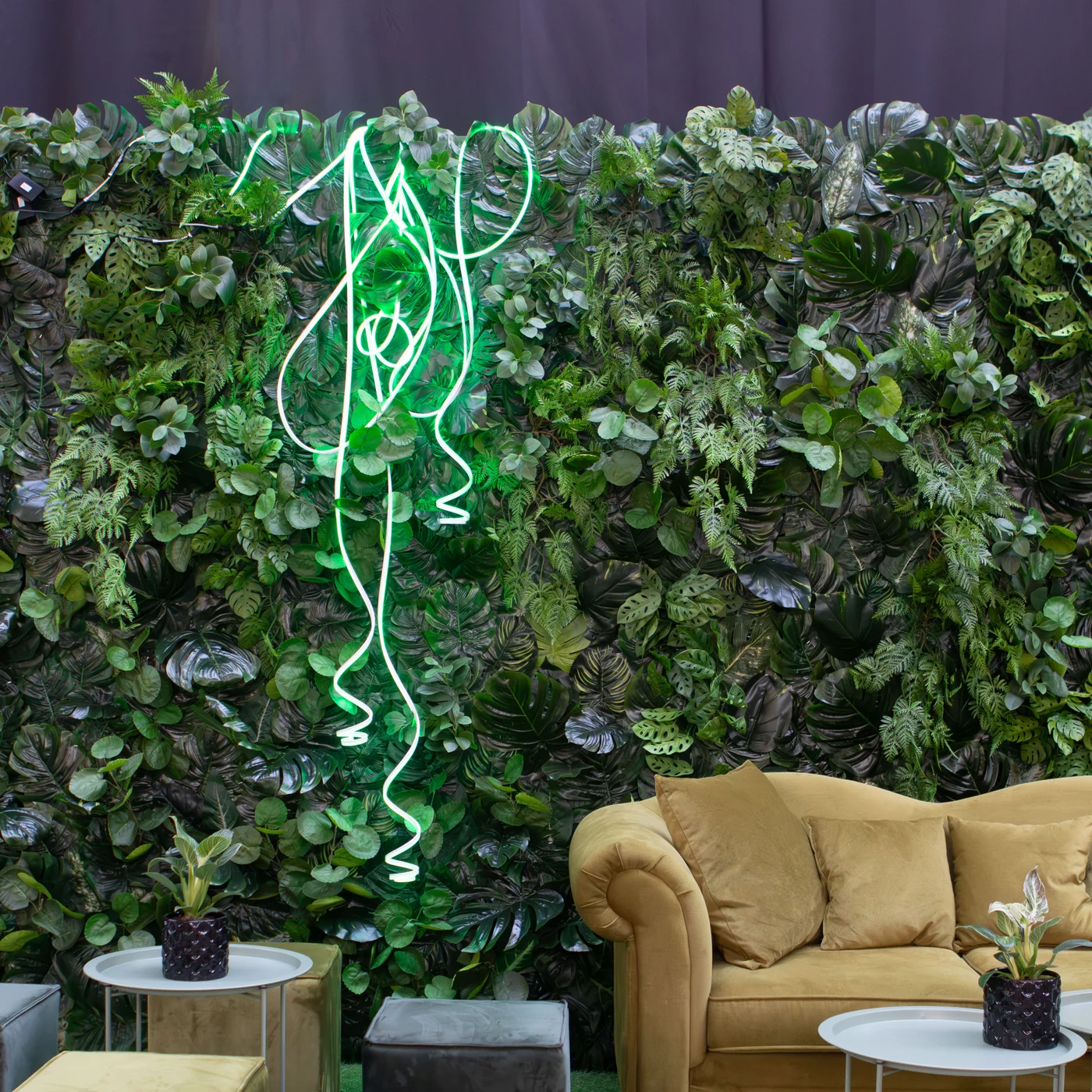 Tropikalna zielona ściana z dekoracyjnym wężem neonowym tworzy wyjątkową scenografię premium inspirowaną naturą i nowoczesnym designem. Połączenie bujnej roślinności, subtelnego zielonego światła oraz eleganckiej strefy lounge z oliwkową sofą sprawia, że aranżacja idealnie nadaje się na strefę chillout na wesele i przeróżne eventy. Wypożyczalnia dekoracji Wrocław rent4events.pl oraz rent4weddings.pl oferuje designerskie dekoracje i kompleksową scenografię dla wyjątkowych realizacji - rent4events.pl wypożycz wrażenia, rent4wedding.pl zachowaj wspomnienia.