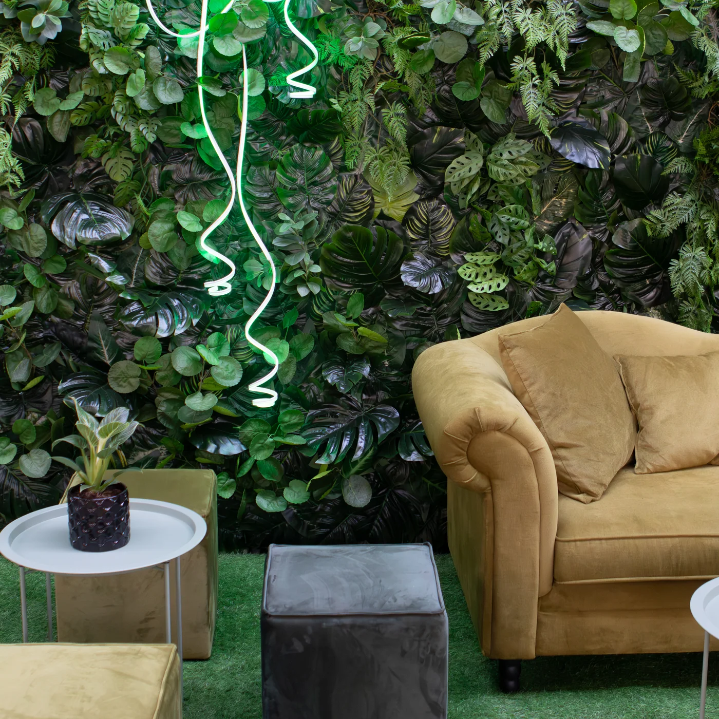 Tropikalna zielona ściana z paprociami, monsterą i dekoracyjnym neonem tworzy efektowną scenografię inspirowaną stylem urban jungle. Oliwkowa sofa oraz minimalistyczne stoliki budują elegancką strefę wypoczynku idealną na ślub, wesele oraz nowoczesny event. Wypożyczalnia dekoracje Wrocław – rent4events.pl i rent4weddings.pl – zapewnia designerskie dekoracje oraz profesjonalną scenografię premium - rent4events.pl wypożycz wrażenia, rent4wedding.pl zachowaj wspomnienia.